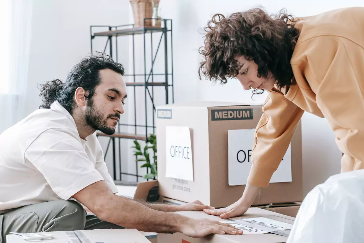 Büromaterial wird geordnet in beschriftete Umzugskartons gepackt