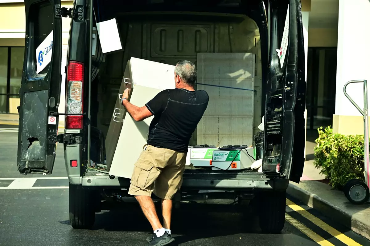Ein Mann lädt Möbel in einen offenen Transporter