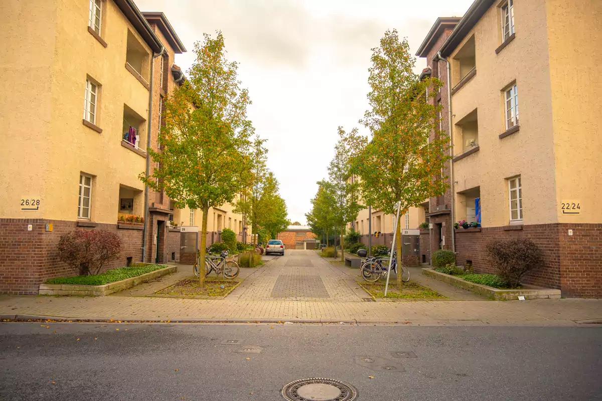 Eine deutsche Wohnstraße mit Fahrrädern, Autos und Bäumen