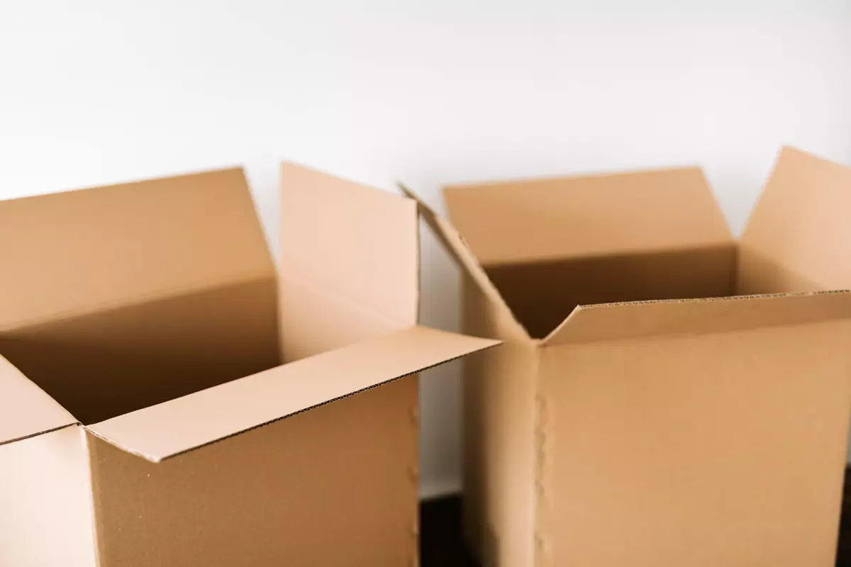 Mehrere offene Umzugskartons stehen zum Packen bereit